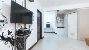 a living room with a flat screen tv on a wall at RedDoorz Plus near Tambo Paranaque in Manila
