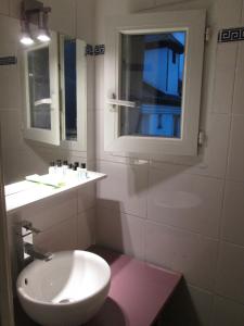 a white bathroom with a sink and a window at Hotel Hauteville Opera in Paris