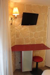 a wall with a tv on a stone wall at Hotel Hauteville Opera in Paris