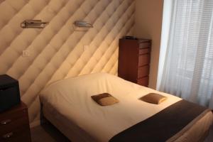 a bedroom with a bed with two pillows on it at Hotel Hauteville Opera in Paris