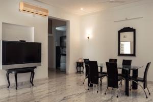 a dining room with a table and a flat screen tv at Casa Romana- Indulgent Comfort in Lake and Hill View Rooms in Udaipur