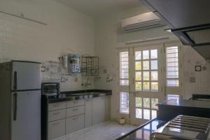 a kitchen with white cabinets and a white refrigerator at Casa Romana- Indulgent Comfort in Lake and Hill View Rooms in Udaipur