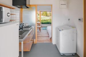a kitchen with a white refrigerator and a table at Passage LODGE Hakuba in Hakuba