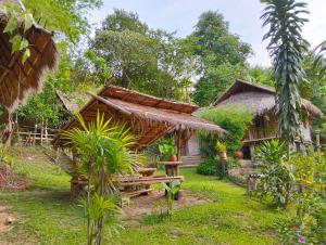 a small hut with a bench in a garden at ecolodge khamu homestay guesthouse in Ban Pak Ing