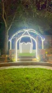 un arco iluminado con una cama blanca con luces en Paris Dream Villa, en Villejuif