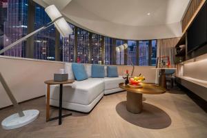a living room with a couch and a large window at Imperial Traders Elong Hotel in Guangzhou