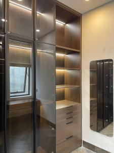 a walk in closet with wooden shelves and a window at Nội homestay in Hue