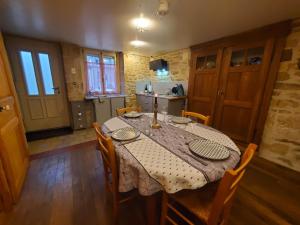 a dining room with a table and chairs and a kitchen at Chez Émile maison d'hotes 2 chambres avec jardin privé in Humes