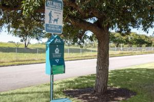 a sign on a pole next to a tree at Hilton Garden Inn Tuscaloosa in Tuscaloosa