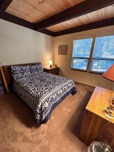 a bedroom with a bed and two windows at Rooted Resort in Kings Beach