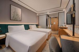 Un ou plusieurs lits dans un hébergement de l'établissement Hilton Garden Inn Shanghai Caoyang