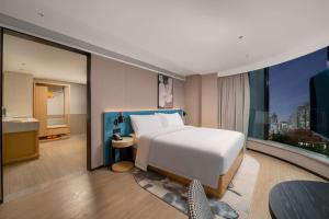 Un ou plusieurs lits dans un hébergement de l'établissement Hilton Garden Inn Shanghai Caoyang