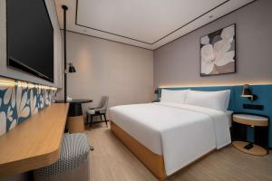 Un ou plusieurs lits dans un hébergement de l'établissement Hilton Garden Inn Shanghai Caoyang
