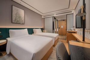 Un ou plusieurs lits dans un hébergement de l'établissement Hilton Garden Inn Shanghai Caoyang