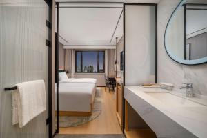 Un ou plusieurs lits dans un hébergement de l'établissement Hilton Garden Inn Shanghai Caoyang