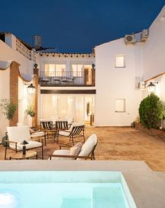 ベレス・マラガにあるPUERTA de la AXARQUIA HOTEL BOUTIQUEの屋外パティオ(椅子、ホットタブ付)