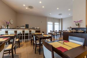 a restaurant with tables and chairs and a bar at Mosaico Suite in Cesena