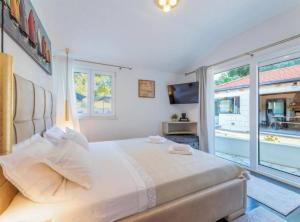 a bedroom with a large bed and a large window at Idyllic Escape Villa Maretici with Pool and Private Garden in Drniš
