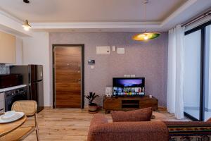 TV a/nebo společenská místnost v ubytování Elite One Bedroom Apartment,Swimming pool, gym, workspace ,Wonderiss Homes close proximity to GTC, JW Mariott and Kempinski + 37 fotografií