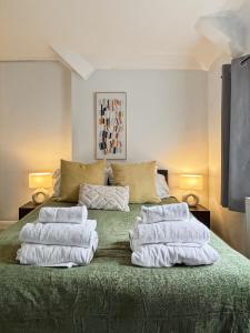 a bedroom with a green bed with white towels on it at Charming Retreat With Hot Tub Sauna Sleeps 4 in Falmer