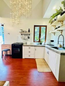 a kitchen with white cabinets and a wooden floor at Tiny Hideaway Luna House with free 2 motorbikes in El Nido