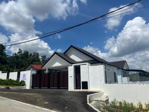 a white house with a fence in front of it at The Jasmine House Desa Putra w Private Pool 5 min Putrajaya in Sepang