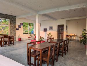 Un comedor con mesas y sillas de madera. en Hobo Hostel, en Dharamshala