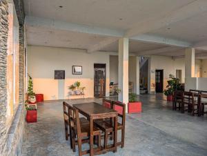 a dining room with a table and some chairs at Hobo Hostel in Dharamshala