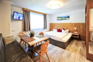 pokój hotelowy z łóżkiem i stołem w obiekcie Bäckerei Schranz w mieście St. Leonhard im Pitztal
