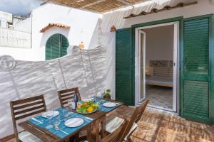 une salle à manger avec des volets verts et une table et des chaises dans l'établissement Casa di Nonno Mario, à Praiano