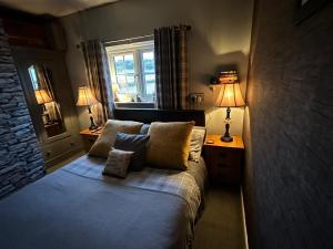 a bedroom with a bed with two lamps and a window at Shropshire Guestroom in Wolverhampton