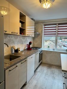 a kitchen with white cabinets and a window at Apartament ultracentral Tarnaveni in Tîrnăveni