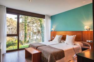 ein Schlafzimmer mit einem Bett und einem großen Fenster in der Unterkunft Hotel Alén do Mar in Kap Finisterre