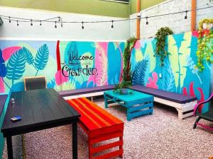 un grupo de bancos en una habitación con una pared colorida en Chillout Hostel Barrio Escalante, en San José