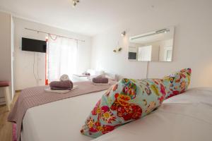 a bedroom with two beds and a mirror at Apartments Fortuna in Novalja