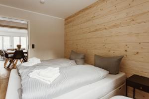 two beds in a room with a wooden wall at Harzchalet Brockenbahn 2A in Elend