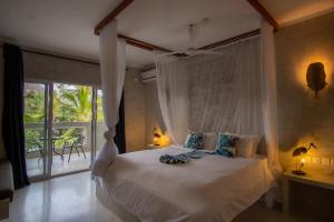 a bedroom with a bed and a large window at Visiwa Beach Resort in Watamu
