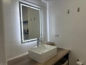 biała łazienka z umywalką i lustrem w obiekcie Lumineux Studio tout équipé w mieście Canet-en-Roussillon +8 zdjęć