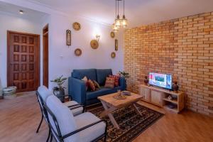a living room with a blue couch and a brick wall at Tooro Green Courts in Namulanda