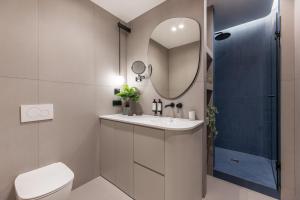 un bagno con lavandino, WC e specchio di Catalog Boutique Rooms Bratislava a Bratislava