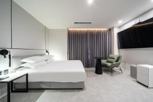 SeosanSeosan Hotel Posto的一间卧室，配有一张床、一张桌子和一把椅子