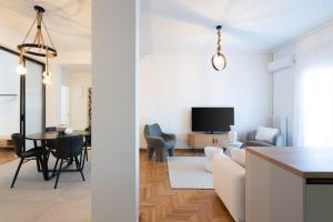 a living room and dining room with a couch and a table at LIV - Elegant City Stay in Pagrati in Athens