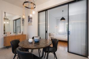 a dining room with a table and chairs and a bedroom at LIV - Elegant City Stay in Pagrati in Athens