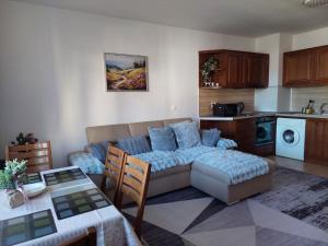 a living room with a couch and a kitchen at Bansko Pirin Golf & Country Club Blue Mountains View in Razlog