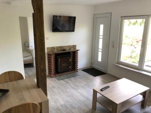 a living room with a fireplace and a tv at Ferienhäuser am Heidesee in Halbe