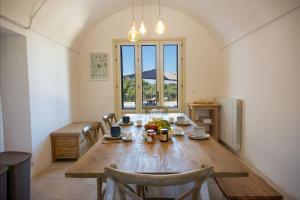 a dining room with a wooden table with chairs at Masseria Comara in Monopoli