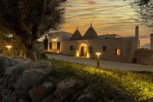 a house with lights in front of it at night at Masseria Comara in Monopoli