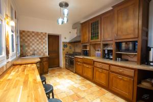 a large kitchen with wooden cabinets and a wooden table at Villa Evasion in Louviers