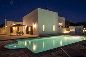 a swimming pool in front of a house at night at Masseria Comara in Monopoli