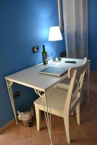 a white table with a lamp and a bottle of wine at B&B O Casteddu in Monforte San Giorgio